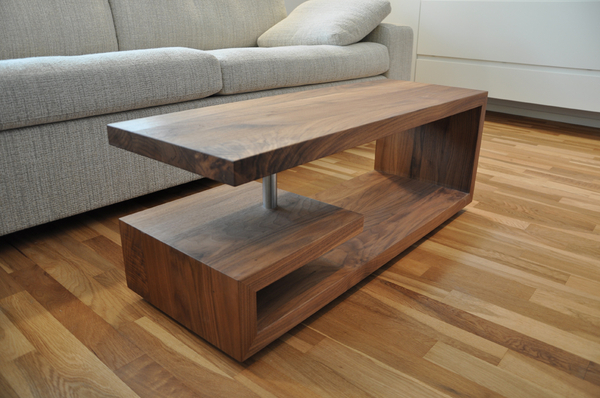 ussbaumtisch – Modern geformter Couchtisch aus massivem Nussbaumholz und dem Edelstahlzylinder als stabilisierende Verbindung zwischen Tischplatte und Unterbau.